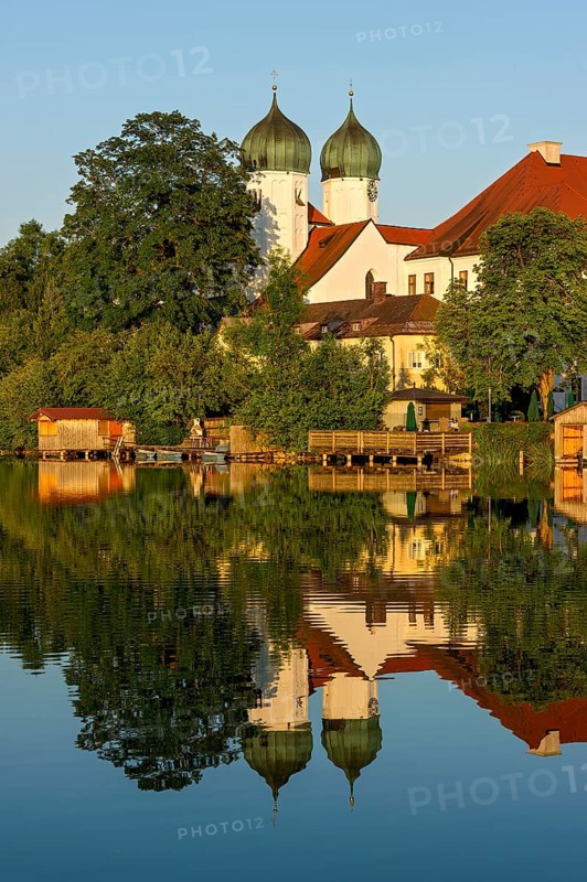 Romanesque Benedictine Abbey Seeon Monastery, monastery church St. Lambert with reflection in the monastery lake, calm smooth water in the evening light at sunset, Seeon-Seebruck, Chiemgau, Upper Bavaria, Bavaria, Germany