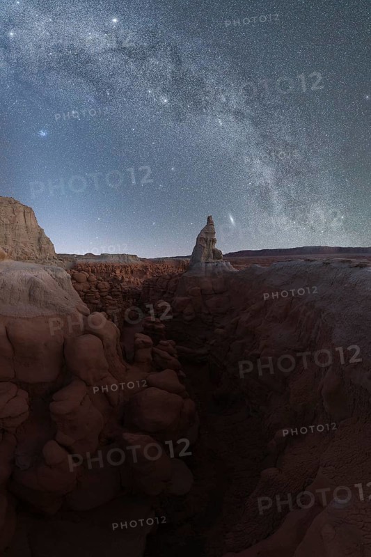 Spectacular view of the Milky Way galaxy over the eerie rock formations of Goblin Valley State Park in Utah, showcasing a clear, star-filled sky and detailed, rugged terrain