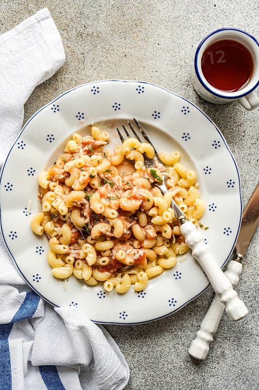 A delicious serving of chifferi rigati pasta, topped with savory tomato sauce and fresh herbs, elegantly plated. The dish exudes Italian culinary charm, perfect for food enthusiasts