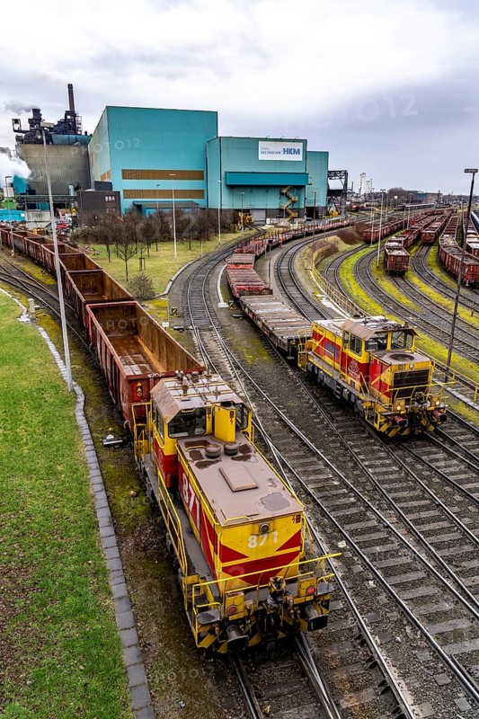 Hüttenwerke Krupp-Mannesmann, HKM in Duisburg, halls of the blast furnace steelworks, tracks of the marshalling yard, locomotive with goods wagons North Rhine-Westphalia, Germany