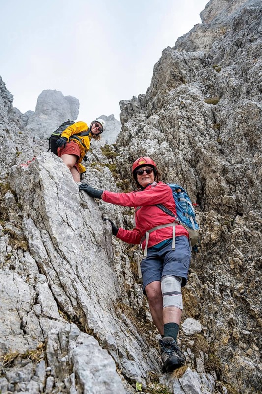 Two mountaineers with helmets climbing on a rock face, ascent to the Ackerlspitze, Wilder Kaiser, Kaiser Mountains, Tyrol, Austria
