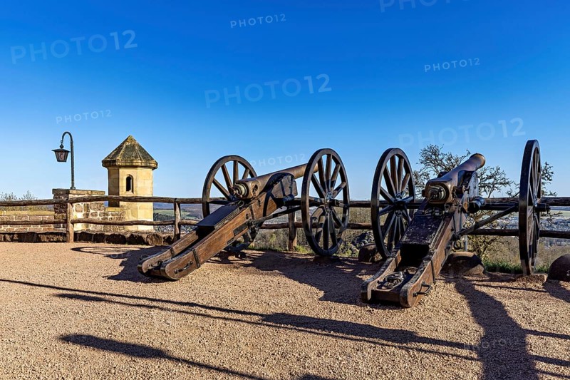 Two old cannons on a sunny spot with a clear sky and a railing in the background, The cannons on the Wartburg redoubt near Eisenach in Thuringia
