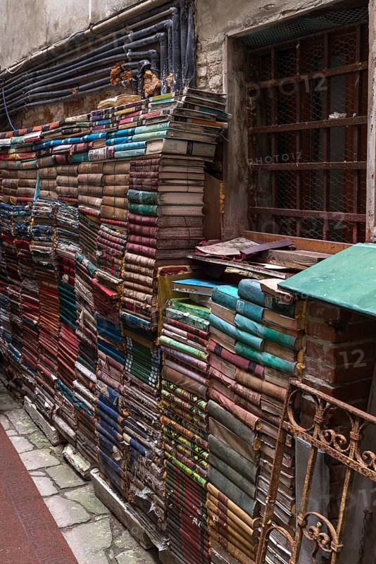 Stacked books on a wall after flood damage in a bookstore, Venice, Veneto, Italy