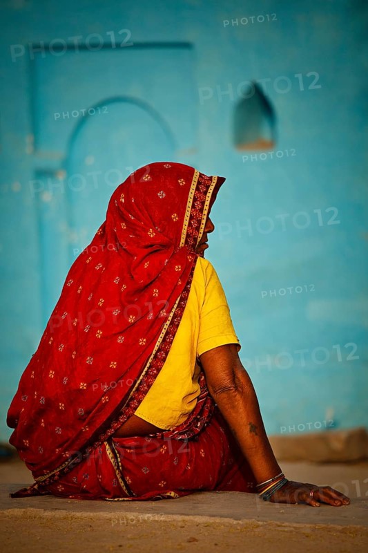 KHAJURAHO, INDIA, APRIL 15, 2011: Indian rural woman in traditional sari sitting in Khajuraho village. The major part of India rural population live the same traditional way as centuries before