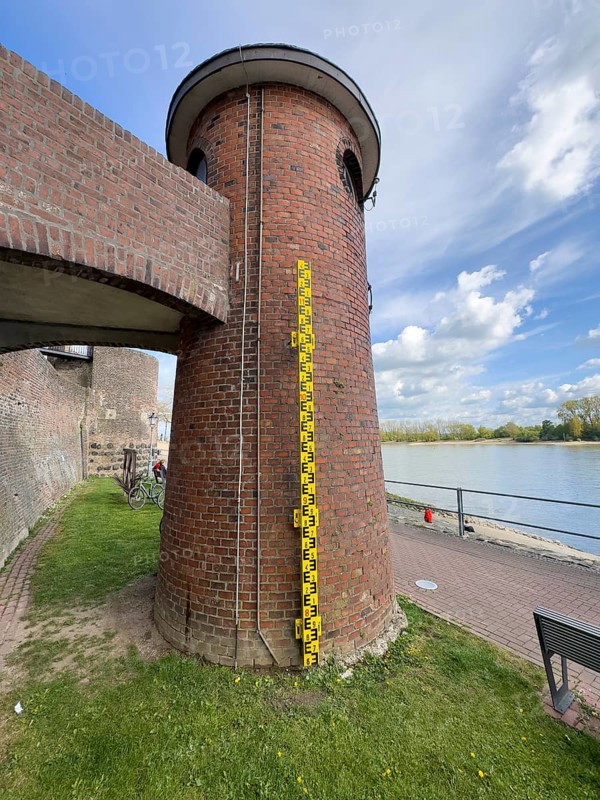 Historic water gauge tower with display for high water level indicator, left in the background remains of historic customs tower, right river Rhine, Rees, Lower Rhine, North Rhine-Westphalia, Germany