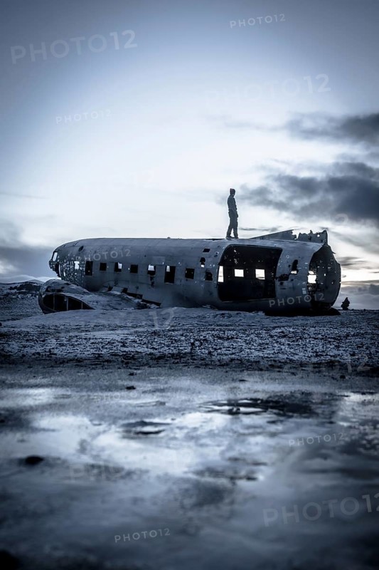 A man on the crashed military plane in Solheimasandur in winter
