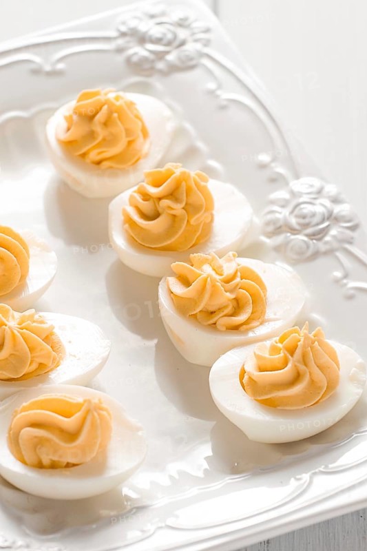 Boiled eggs stuffed with yolk with mayonnaise, on a white plate, selective focus, blurry, close-up, no people