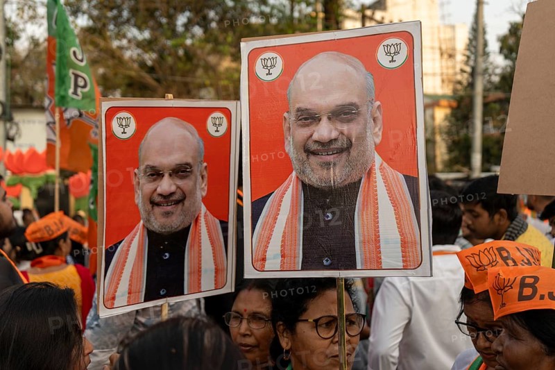 Supporters hold placards featuring Amit Shah during a public rally of the Bharatiya Janata Party ahead of the Assam Assembly Election 2026 in Guwahati, India on 28 March 2026