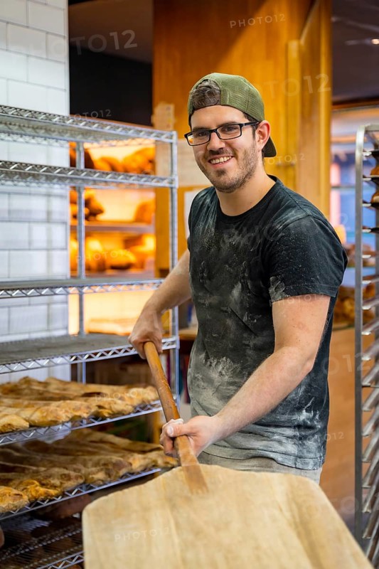 Portrait of baker of bakery in the workshop workshop of artisan bakery with the shovel of bread for the oven