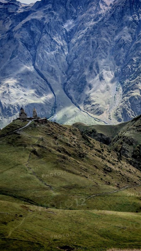 Panoramic view of Gergeti church and mountains, dominating natural scenery, Stepantsminda, Caucasus, Georgia