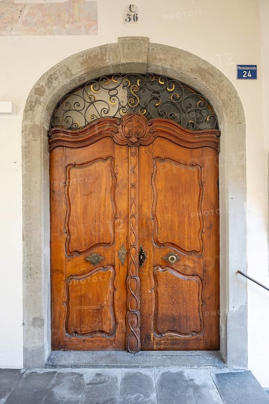 Artfully carved, baroque wooden door in a stone arched portal in the old town of Lindau, Bavaria, Germany