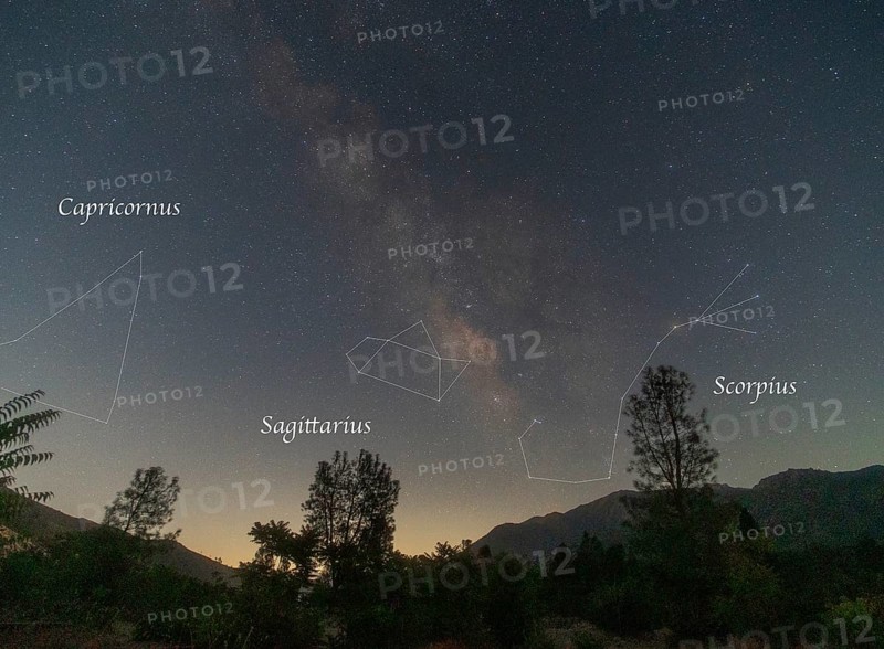 A spectacular night sky over Sequoia National Park, featuring the Milky Way with constellation outlines of Capricornus, Sagittarius, and Scorpius visible