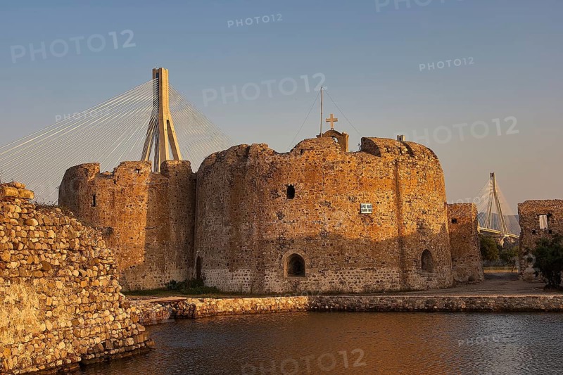 Historic fortress walls and a large tower with a modern bridge in the background, Rio-Antirrio cable car bridge, Rio fortress, Patras, Peloponnese, Greece