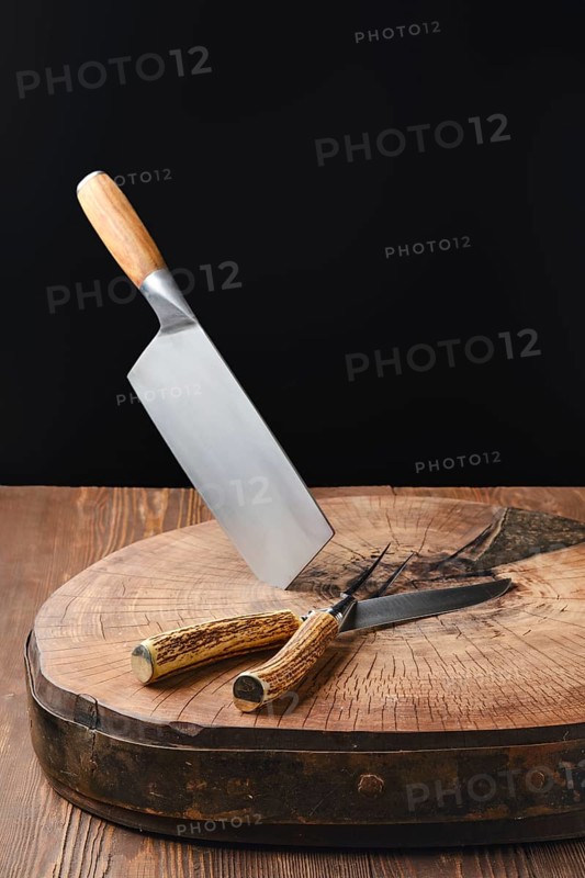 Cleaver, fork and knife on wooden stump