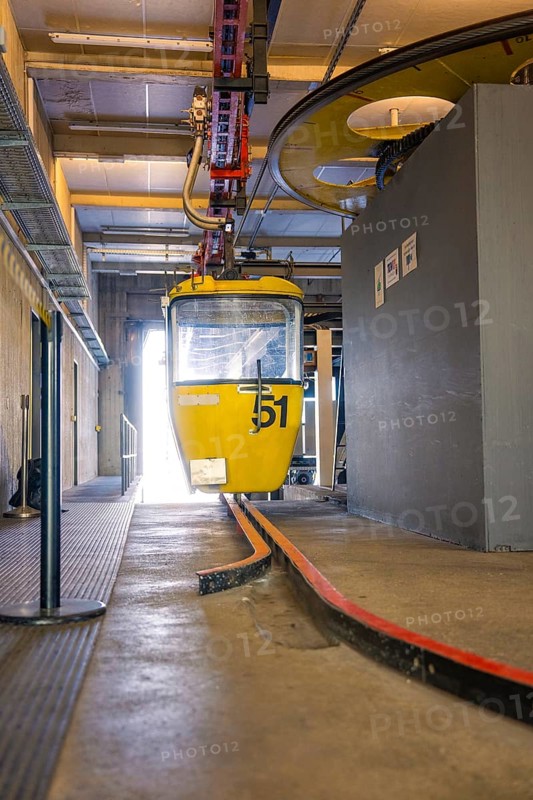 Yellow cable car cabin in a station surrounded by technical equipment, Hochgrat Mountains, Allgäu Alps, Oberreute, Germany