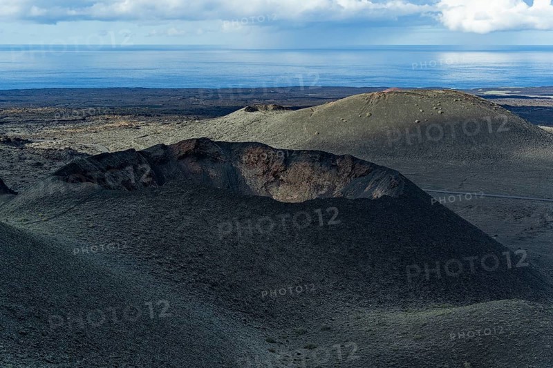Explore the dramatic volcanic landscape of Timanfaya National Park in Lanzarote, Spain. The rugged terrain, shaped by volcanic activity, offers breathtaking views of craters and lava fields