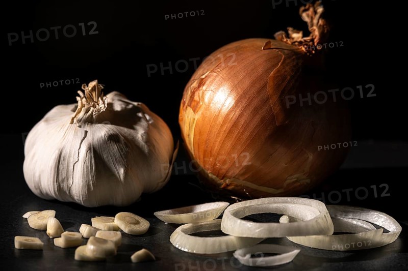 Onion and garlic, cut and whole, dark background