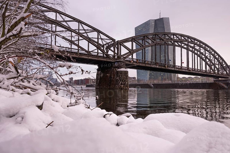 Snow lies along the banks of the Main from the European Central Bank (ECB) to the Frankfurt banking skyline, Osthafen, Frankfurt am Main, Hesse, Germany