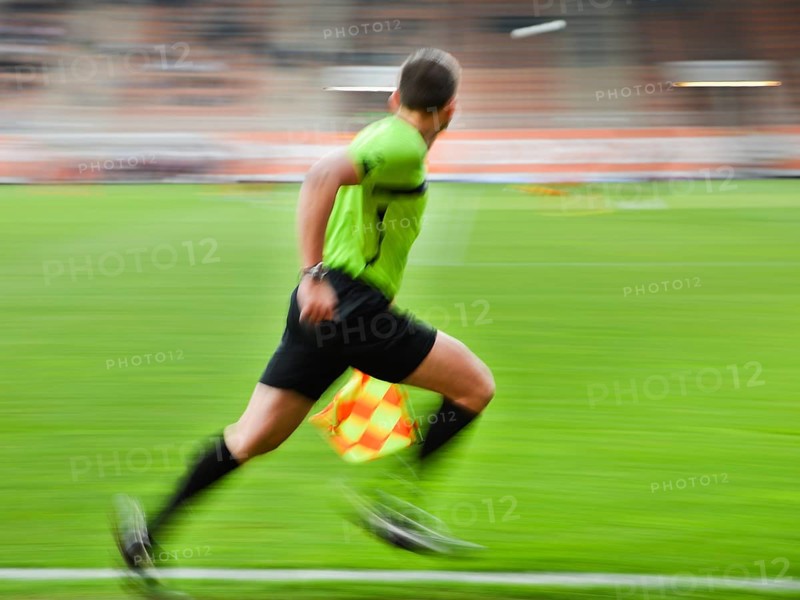 Sideline football referee runs during the match. Panning technic, in Lubin, Poland