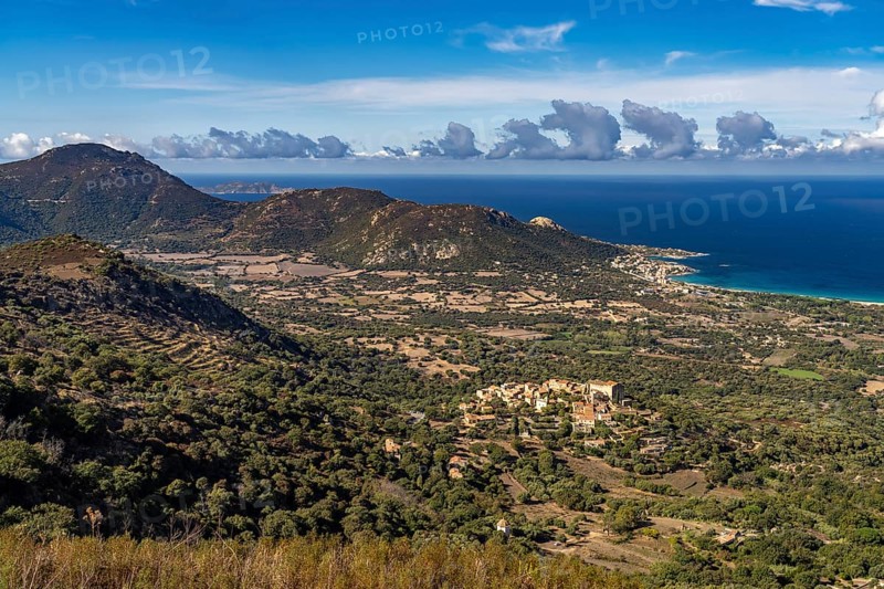 The Balagne countryside with the village of Pgna and the coast near Algajola seen from above, Balagne, Corsica, France