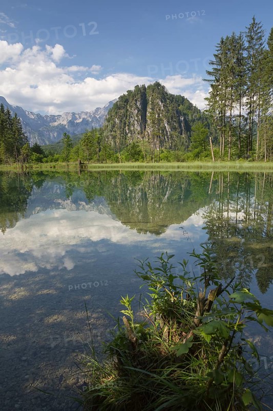 Lake Almsee in summer with totally smooth surface showing reflexion of the mountain Ameisstein
