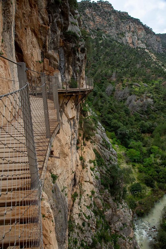 Narrow wooden path along a steep rock face above a gorge on the Caminito del Rey, Malaga, Spain