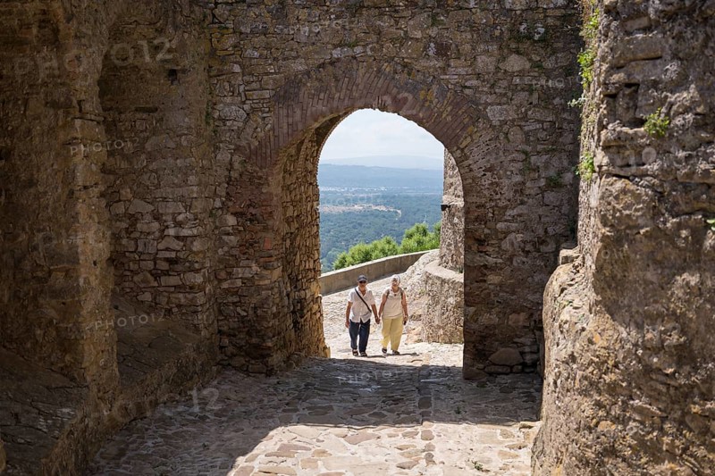A senior couple enjoys a leisurely walk through a charming historic white village in Southern Spain, capturing the essence of relaxation and exploration during their vacation
