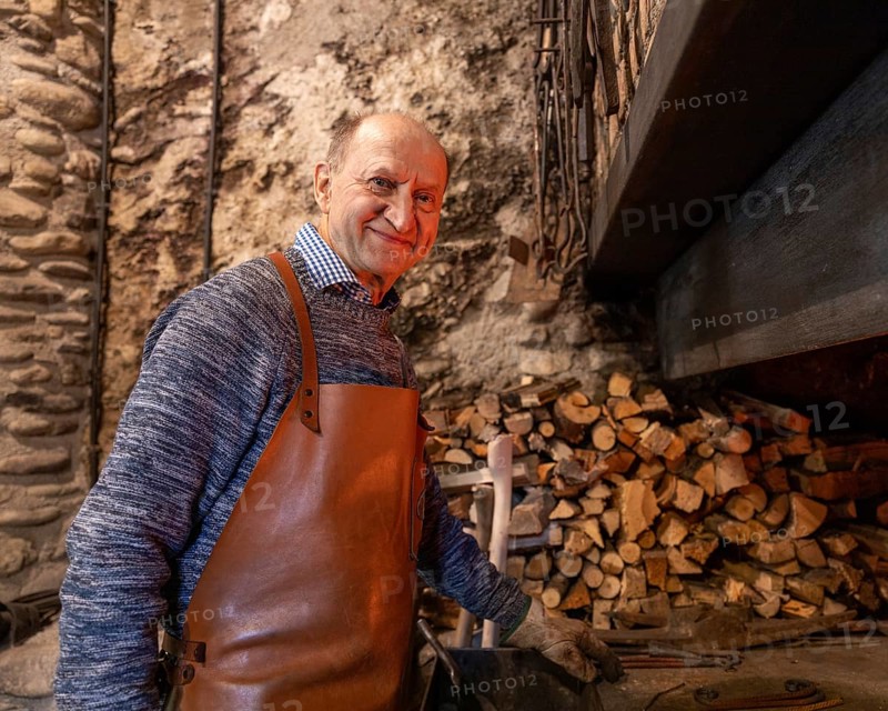 An elderly blacksmith in the Salzburg region of Austria keeps the craft alive, showcasing centuries-old techniques and traditions in his workshop, surrounded by tools and raw materials