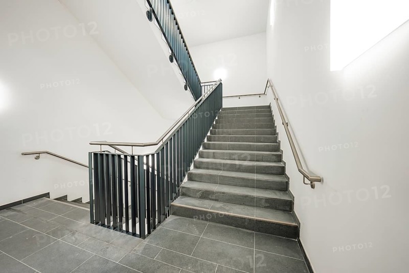 Bright, modern staircase with grey tiles and a simple metal railing, new Calw Hospital, Germany