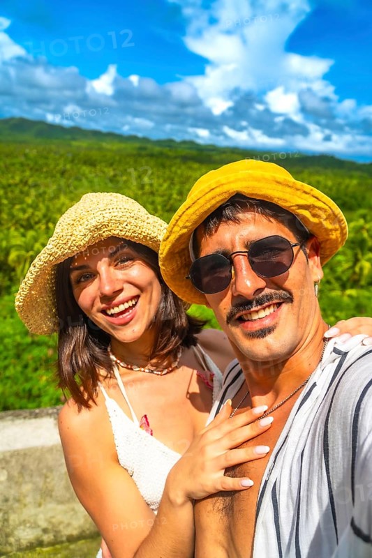 Tourists taking selfie with tropical forest in background during summer vacation in philippines