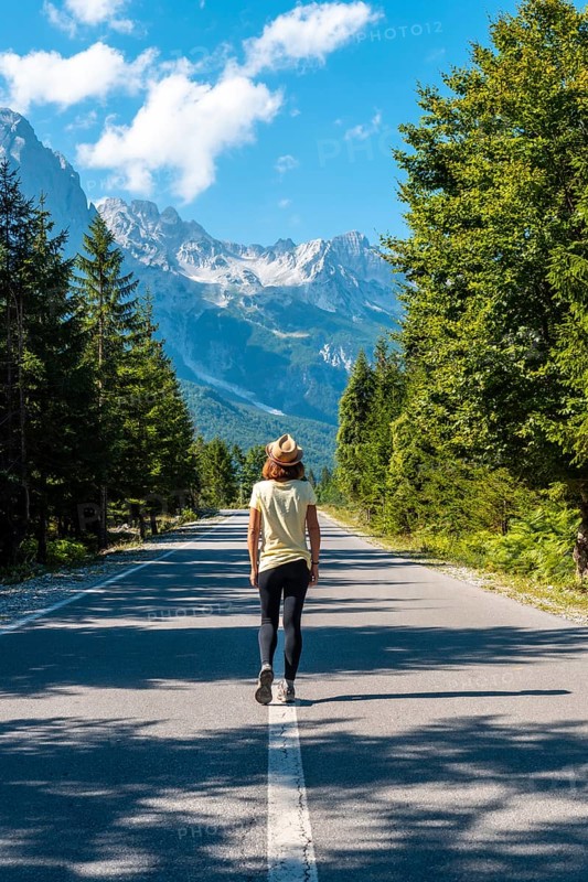 A woman walking on the road in the Valbona Valley, Theth National Park, Albanian Alps, Valbona Albania