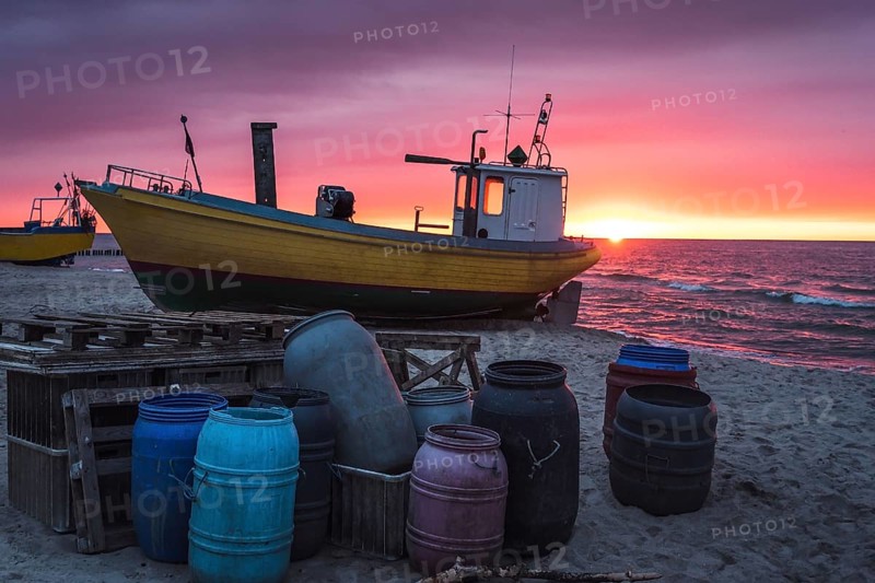 Fishing boat on the beach at sunset. Baltic sea