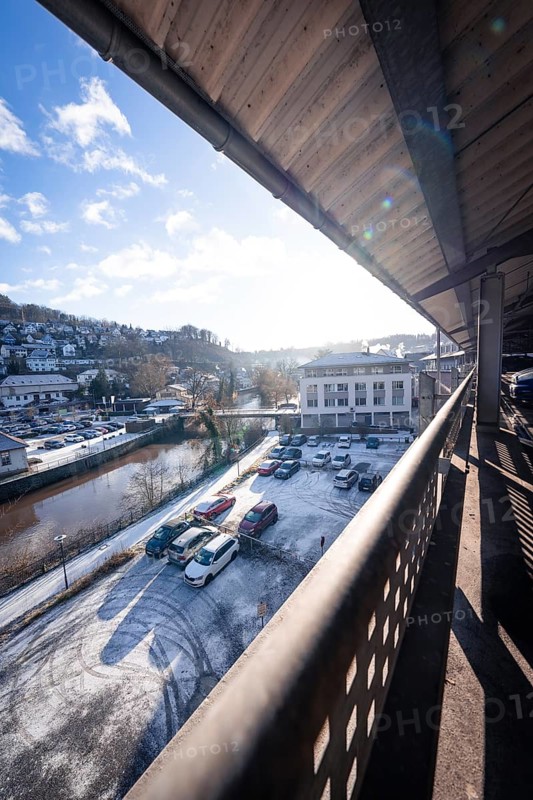 Car park deck and surroundings in winter with snow residues on cars and sunny sky, Kaufland Calw car park, Calw district, Black Forest, Germany