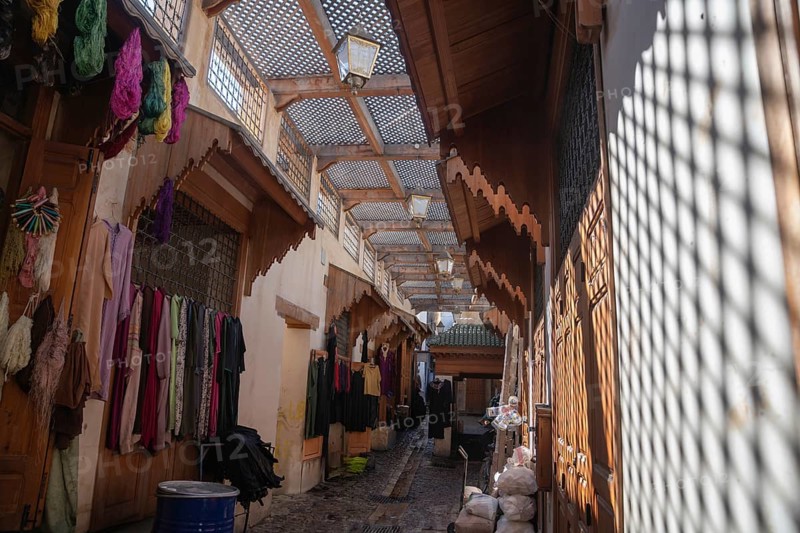 Traditional Moroccan street with typical clothing stores from the city of Fez. The solitary scene represents the tranquility and harmony of the area
