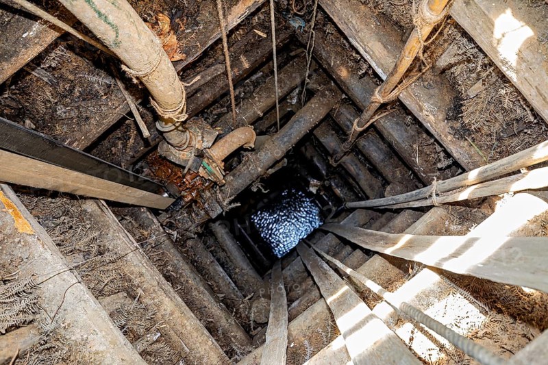 View of a deep wooden well with visible water at the end, The sapphire and gemstone mines at Ratnapura in Sri Lanka