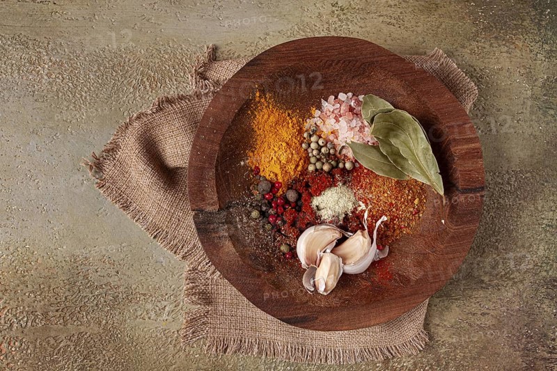 Spice mix, garlic and bay leaf, on a wooden plate, close-up, food concept, no people