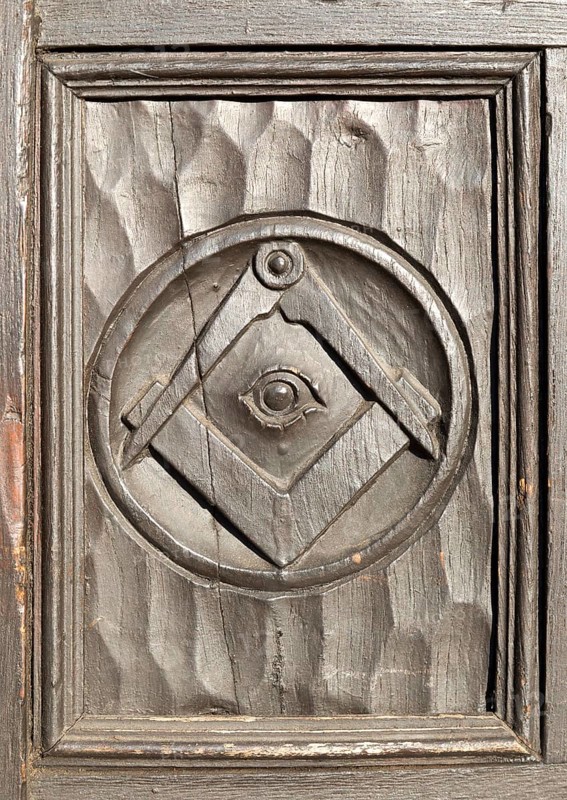 Historic carved masonic symbols on wooden panel on door of house in Marlborough, Wiltshire, England, UK