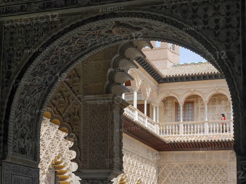 Real Alcazar, decorated arch overlooking ornate courtyard architecture and historic details, Seville, Andalusia, Spain