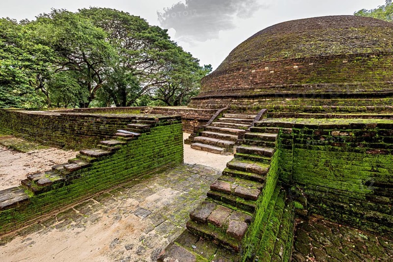 Stupa with worn stairs and moss-covered brick walls, temple ruins near Sigiriya in Sri Lanka
