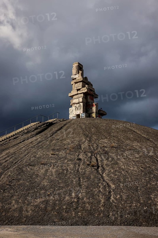 Gelsenkirchen, North Rhine-Westphalia, Germany - Rheinelbe slagheap with artwork Himmelstreppe made of old concrete parts of the former Rheinelbe colliery in front of a dark sky, artist Herman Prigann
