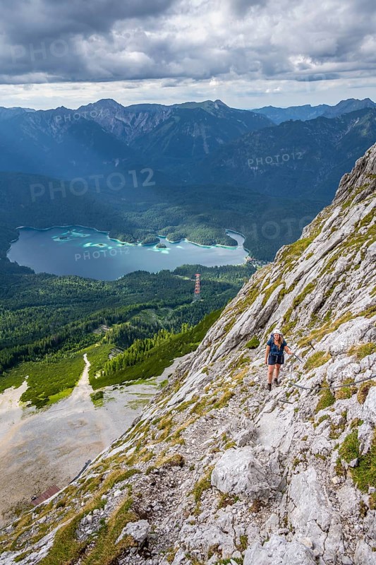 Via ferrata over the Riffelscharte, hiker in the mountains, view of Eibsee lake and Werdenfelser Land, Wetterstein Mountains, Garmisch-Patenkirchen, Bavaria, Germany