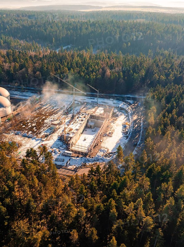 Viewed from above, a winter forest shows a construction site with cranes, surrounded by snow, new fire station, Oberhaugsett, district of Calw, Germany