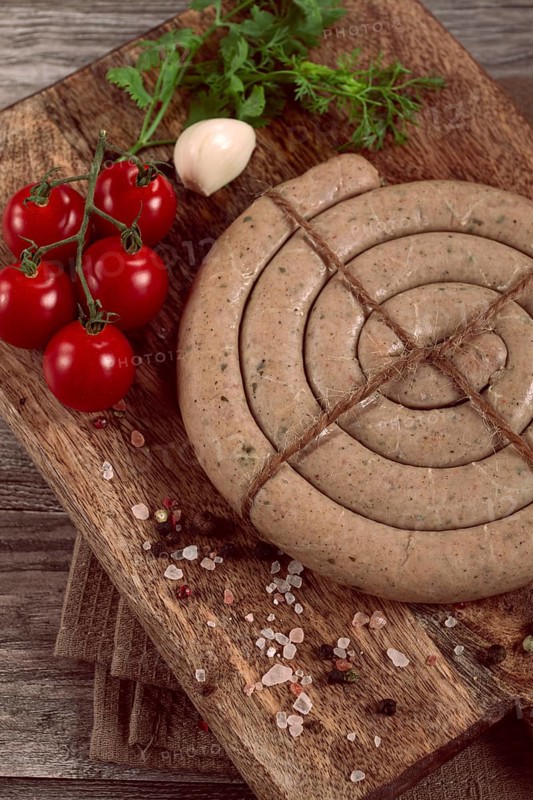 Raw spiral sausages, on a wooden board, top view, no people