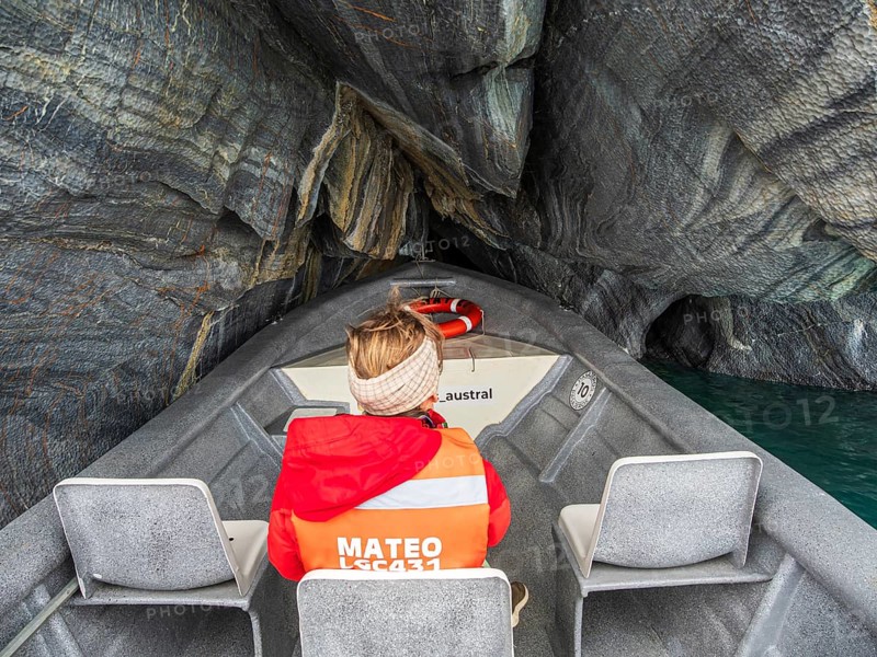 Woman sitting at the front of a tour boat, excursion boat inside the marble caves, Puerto Sanchez, lake Lago General Carrera, Chile
