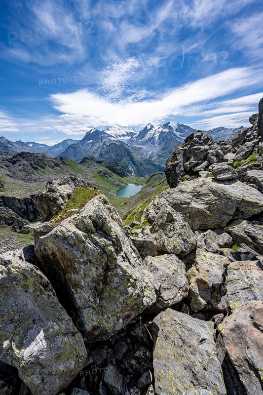 View of mountain lake Lac du Louvie and glaciated mountain peaks of the Grand Combine, Valais Alps, Val de Bagnes, Valais, Switzerland