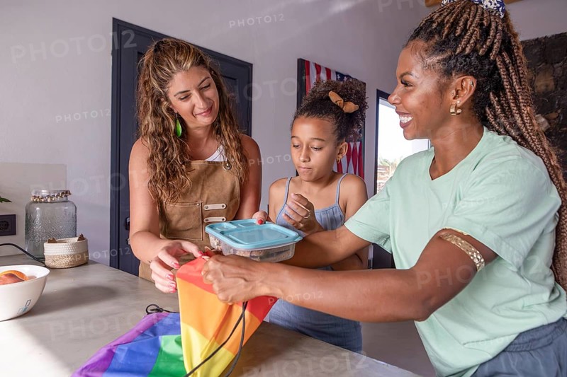 A joyful lesbian family shares a moment together at home, highlighting love, pride, and inclusivity. Celebrating identity and unity in everyday life