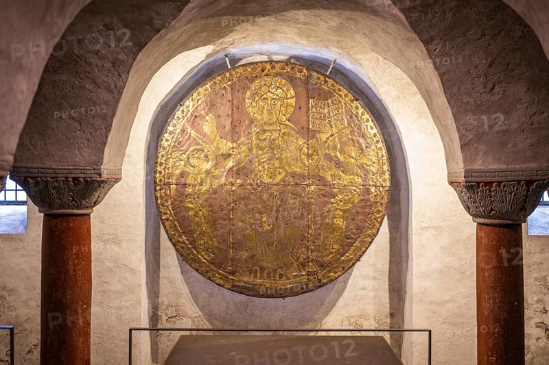 Close-up of a medieval, circular and fire-gilded copper disc, Christ disc from the 10th century (ca. 980 AD) by an unknown master, depicting Christ enthroned as world ruler between two angels in the crypt of Constance Cathedral, Constance, district of Constance, Baden-Württemberg, Germany