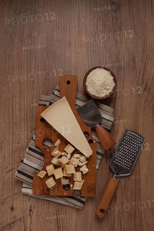 Freshly sliced and grated cheese, parmesan cheese, Gran gusto. Grana padano. on a wooden chopping board, rustic style, no people