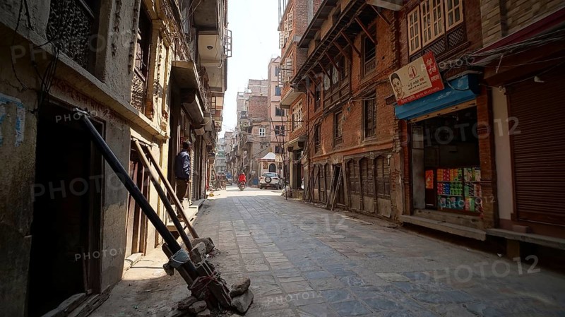 Narrow, quiet alley in Kathmandu with traditional architecture and sunlight, houses are secured and supported shortly after the earthquake in Kathmandu, Nepal