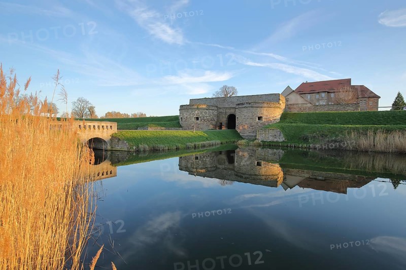 Renaissance moated castle with pond and golden reed grass on the shore, reflection, fortress, lighting atmosphere, Heldrungen, Kyffhäuser, Thuringia, Germany